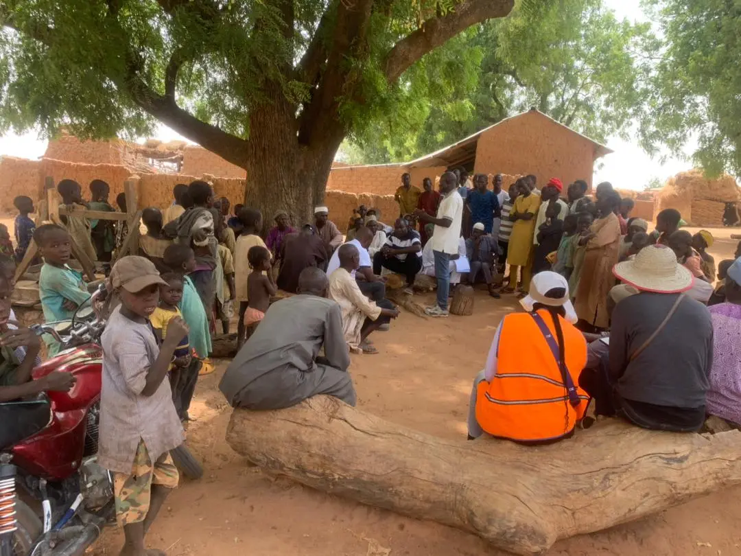 A Go Green Nigeria Foundation facilitator leading a community session under a tree