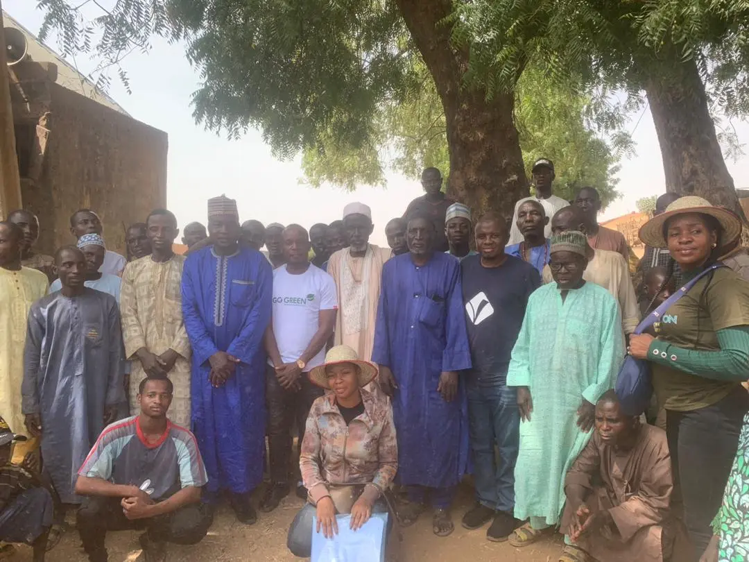 Community members and foundation volunteers gathered under a tree